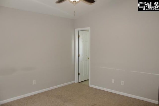 carpeted empty room with a ceiling fan and baseboards