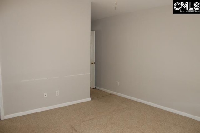 carpeted spare room with a ceiling fan and baseboards