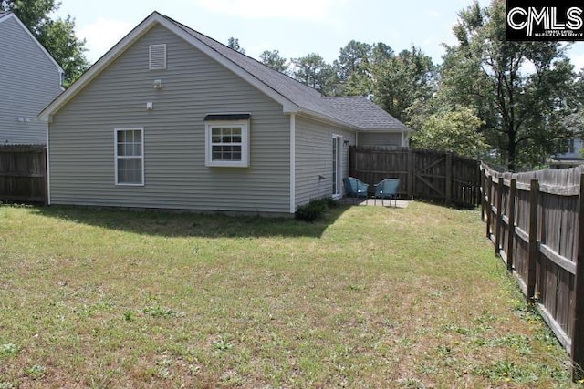 back of property with a fenced backyard and a yard