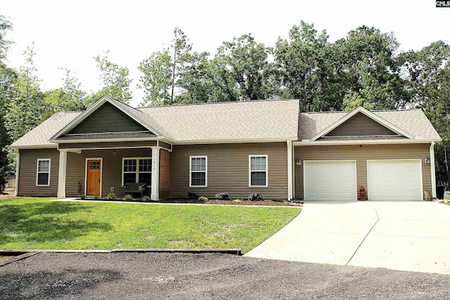 view of front of home with a garage, a shingled roof, a front yard, and concrete driveway