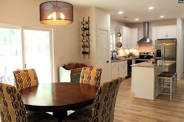 dining area with light wood-type flooring and recessed lighting