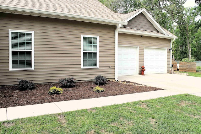 view of property exterior with concrete driveway and roof with shingles