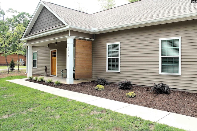 exterior space featuring a lawn, a shingled roof, and covered porch