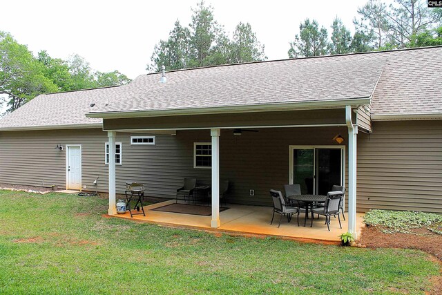 rear view of house with a lawn, a deck, and a shingled roof