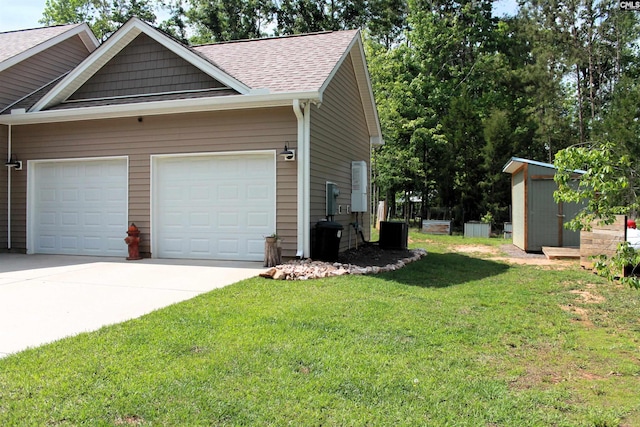 view of side of home featuring a storage unit, a shingled roof, a garage, driveway, and a lawn