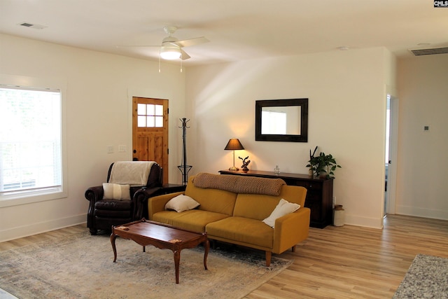 living room featuring visible vents, ceiling fan, and light wood-style flooring