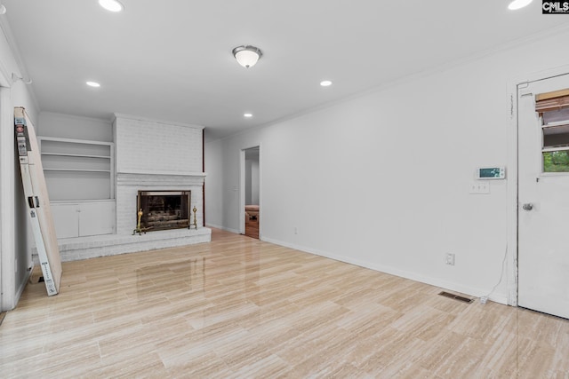 unfurnished living room with visible vents, crown molding, recessed lighting, and a brick fireplace