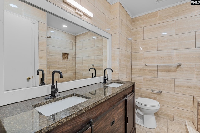 full bathroom featuring double vanity, toilet, ornamental molding, and a sink