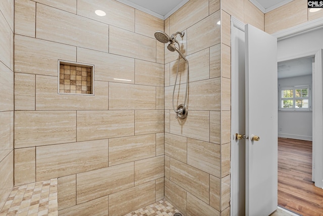 bathroom featuring ornamental molding and a tile shower
