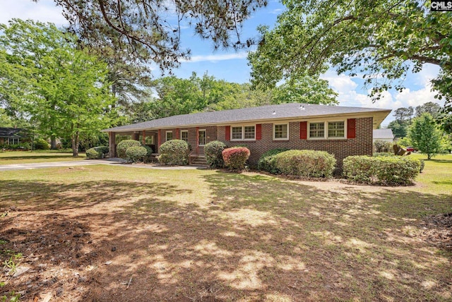 ranch-style house featuring brick siding, a front lawn, and concrete driveway