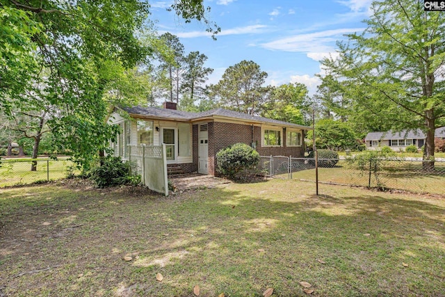 exterior space featuring a chimney, brick siding, fence, and a lawn