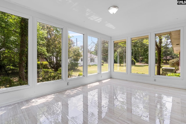 unfurnished sunroom with tile patterned floors and baseboards