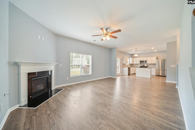 unfurnished living room with baseboards, recessed lighting, a ceiling fan, and light wood finished floors