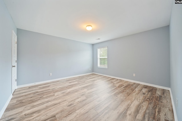 unfurnished room with light wood finished floors and baseboards