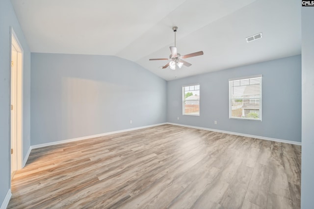 empty room with light wood-style floors, a ceiling fan, visible vents, baseboards, and lofted ceiling