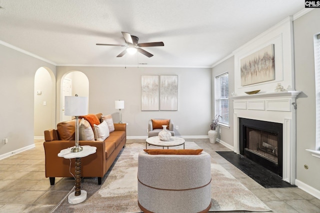 208 Bailey Island Cir, Lexington, SC 29072 - living room featuring a fireplace with flush hearth, baseboards, arched walkways, ornamental molding, and a ceiling fan