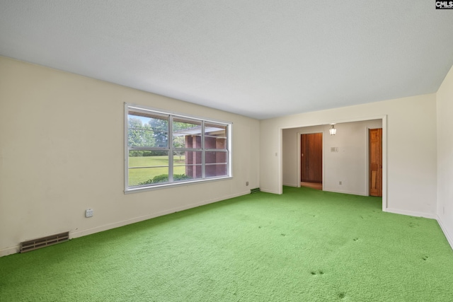 empty room featuring light colored carpet, visible vents, and baseboards