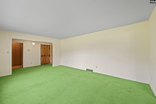 empty room with visible vents, carpet flooring, and baseboards