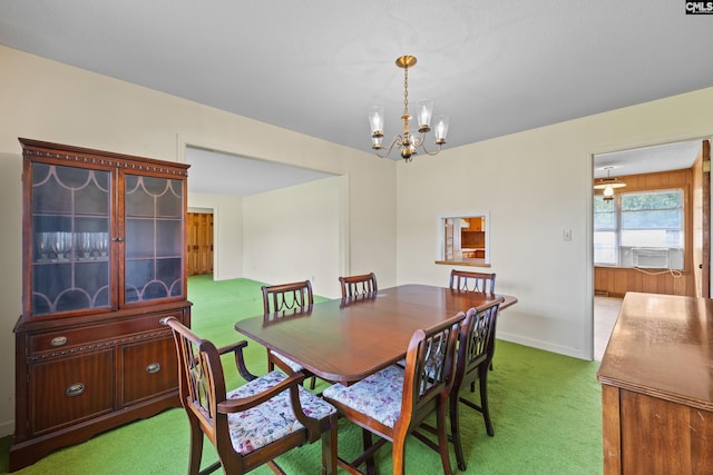 carpeted dining space featuring a chandelier and baseboards