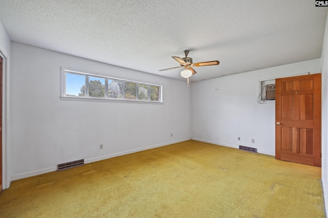 carpeted spare room with visible vents, ceiling fan, and baseboards