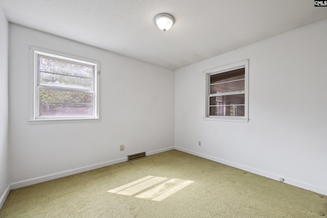 unfurnished room with visible vents, carpet, and baseboards