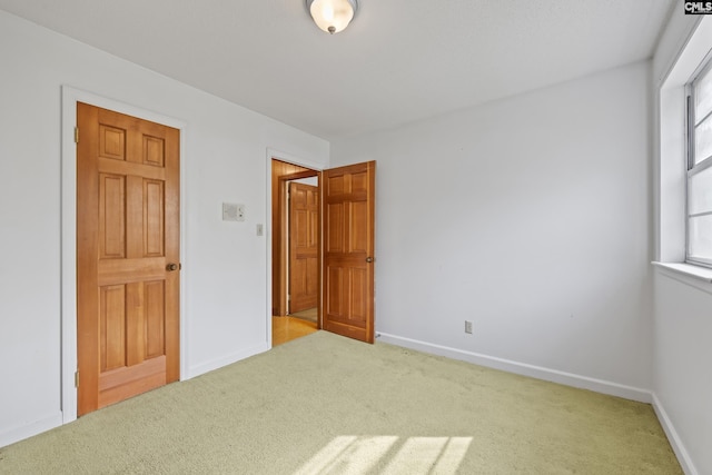 unfurnished bedroom featuring carpet floors and baseboards