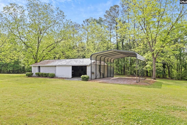 view of yard featuring a carport, an outbuilding, and driveway