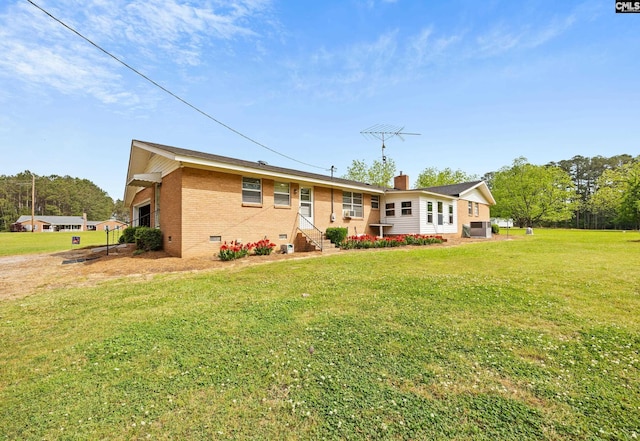 view of front of house with entry steps, central air condition unit, crawl space, brick siding, and a front lawn