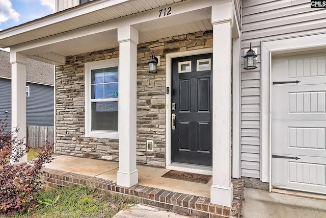 property entrance featuring a porch and stone siding