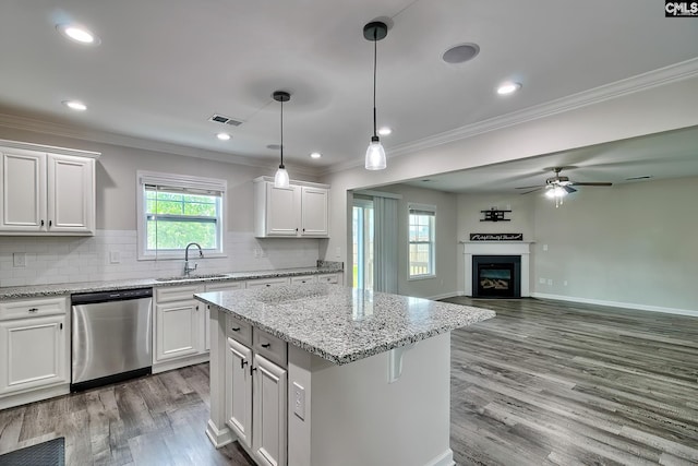 kitchen with a sink, ceiling fan, visible vents, ornamental molding, and dishwasher