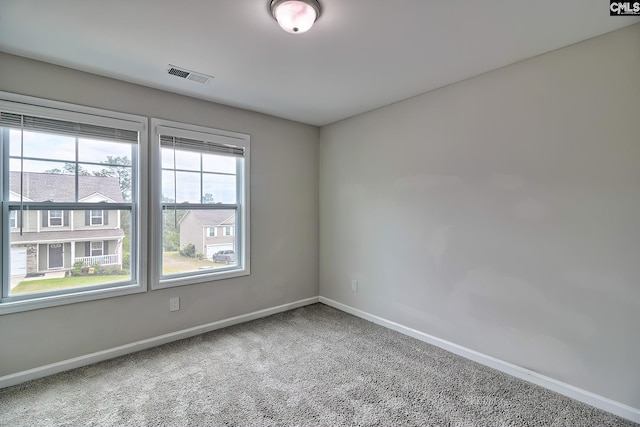 carpeted empty room with baseboards and visible vents