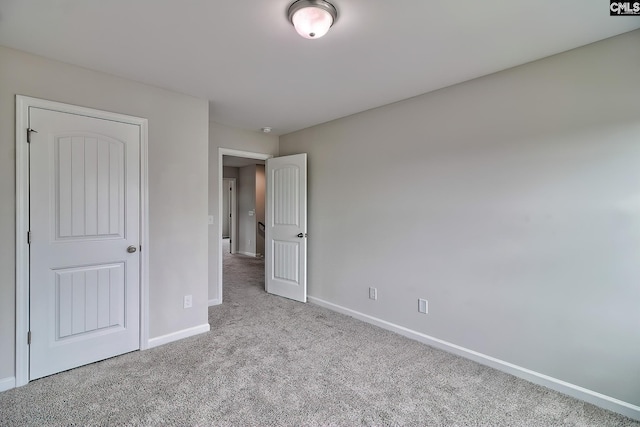 unfurnished bedroom featuring carpet floors and baseboards
