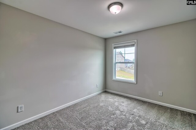 empty room featuring baseboards, visible vents, and carpet flooring