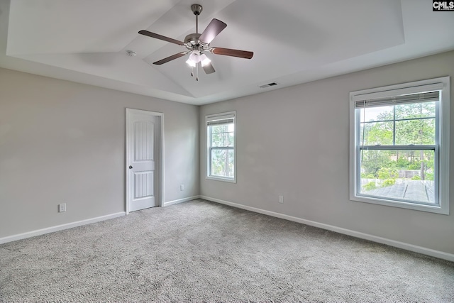 empty room with baseboards, visible vents, a ceiling fan, and carpet