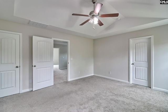 unfurnished bedroom featuring lofted ceiling, visible vents, baseboards, and carpet floors