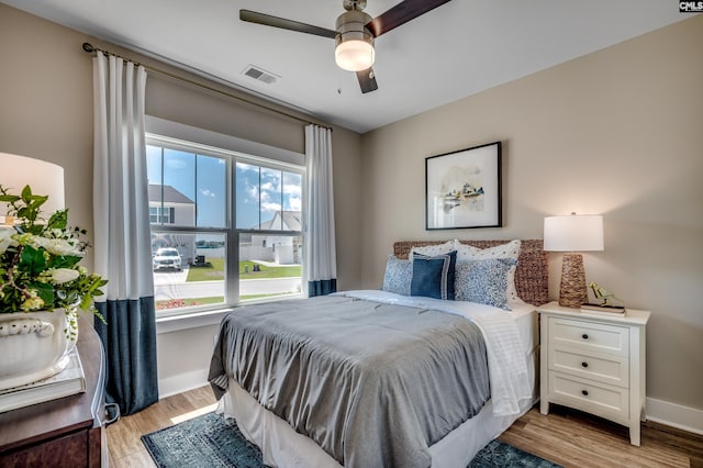 bedroom featuring visible vents, light wood-type flooring, and baseboards