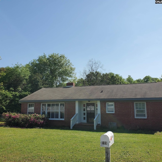 ranch-style house featuring a front lawn and brick siding