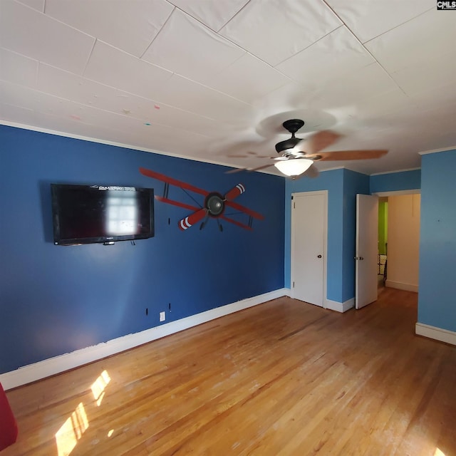 unfurnished room with wood finished floors, ceiling fan, and baseboards