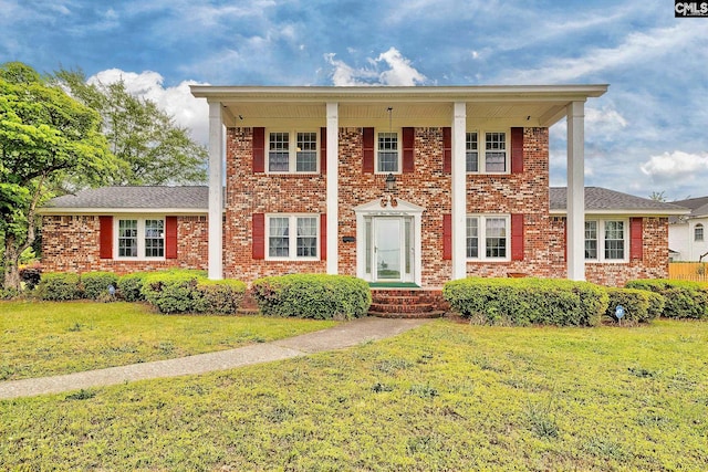 view of front of house featuring brick siding and a front lawn