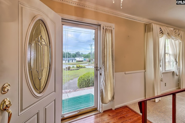 entrance foyer featuring crown molding, baseboards, and light wood-type flooring