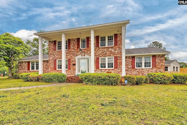 greek revival inspired property featuring brick siding and a front lawn