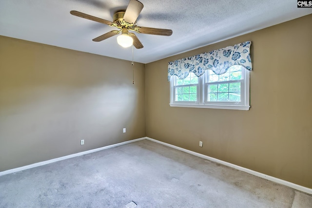 spare room featuring baseboards, ceiling fan, and carpet