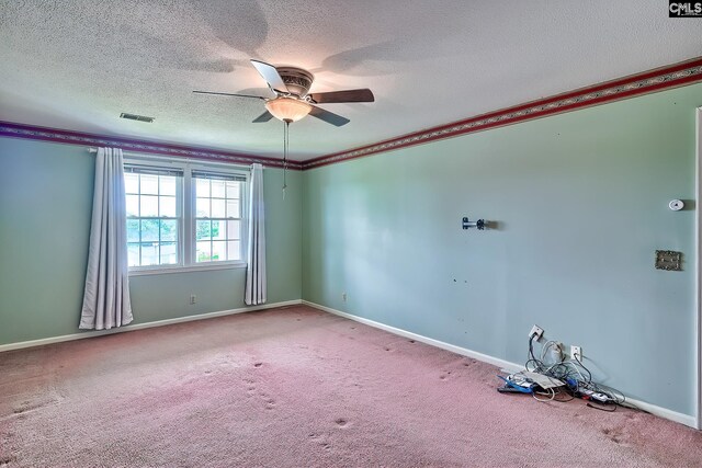 spare room featuring carpet flooring, ceiling fan, visible vents, baseboards, and a textured ceiling