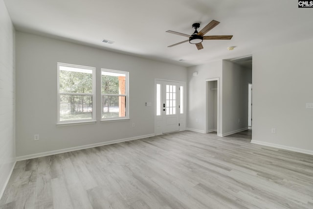 unfurnished living room with baseboards, visible vents, ceiling fan, and light wood-style floors