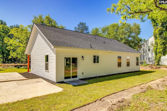 rear view of property featuring a patio and a lawn