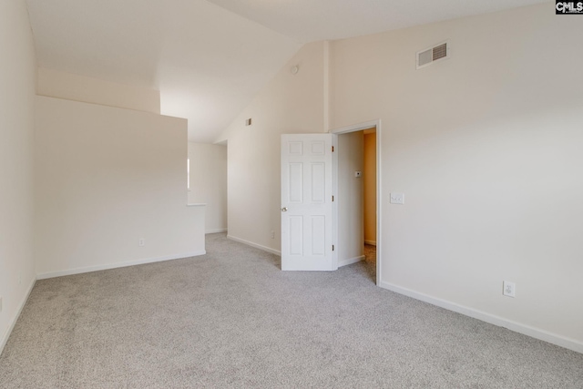 empty room featuring visible vents, high vaulted ceiling, light carpet, and baseboards