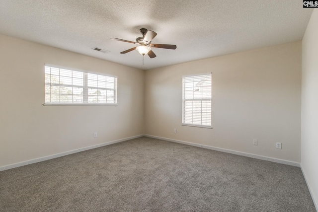 carpeted spare room with ceiling fan, a wealth of natural light, and baseboards