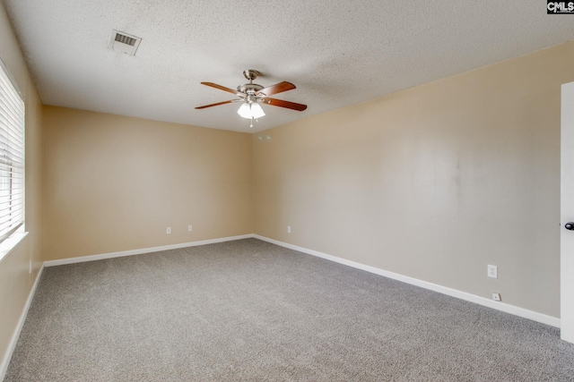 empty room with visible vents, ceiling fan, carpet flooring, and a healthy amount of sunlight