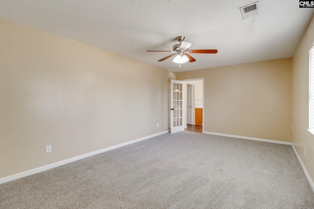spare room featuring baseboards, visible vents, a ceiling fan, and carpet flooring