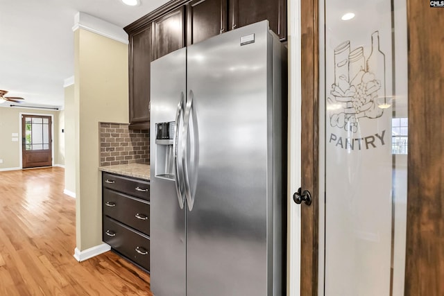 kitchen featuring decorative backsplash, stainless steel refrigerator with ice dispenser, dark brown cabinets, baseboards, and light wood-style floors